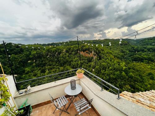 a balcony with a table and chairs and a view at Calcata - La Casa sui Tetti in Calcata