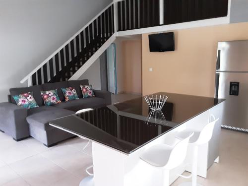 a living room with a table and a couch at Ti Kaz en Nou' in Pointe-Noire