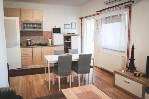 cocina y comedor con mesa y sillas en Apartman Viljevac, Donji Miholjac, en Donji Miholjac