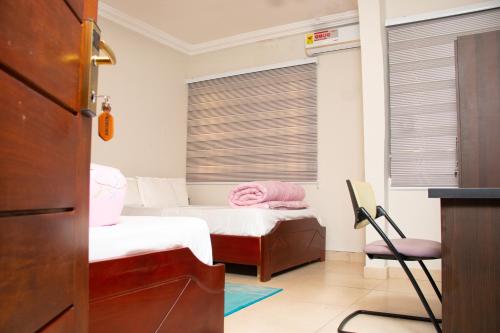 AfwerasiにあるEl-King Home Lodgeのベッドルーム1室(ベッド2台、ブラインド付きの窓付)が備わります。