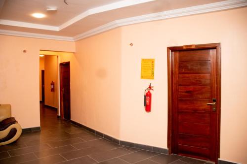 a hallway with a door and a fire extinguisher on the wall at El-King Home Lodge in Afwerasi
