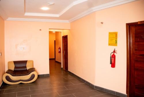 a chair in a hallway with a fire extinguisher at El-King Home Lodge in Afwerasi