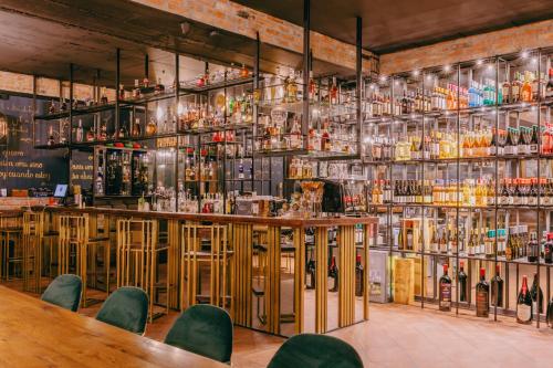 a bar with green chairs and bottles of alcohol at Mtserlebi Resort in K'vishkhet'i