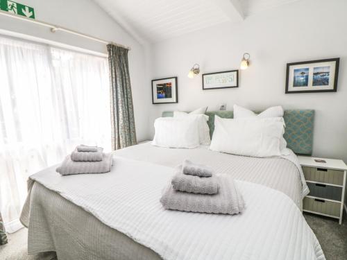 1 dormitorio con 2 camas y toallas. en Little Westwards, en Penzance