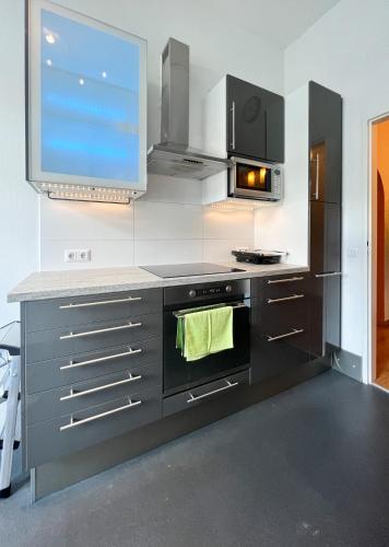a kitchen with a stove and a microwave at Bezaubernde Wohnung in zentraler Lage in Karlsruhe