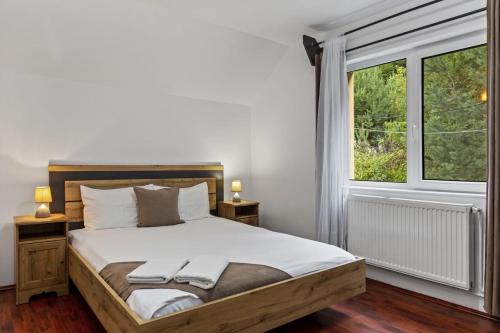 ein Schlafzimmer mit einem Bett und einem großen Fenster in der Unterkunft Casa Georgea in Săcele