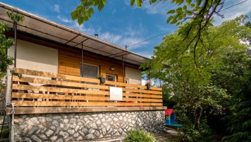 a house with a wooden fence in front of it at Lianne Apartman in Miskolctapolca