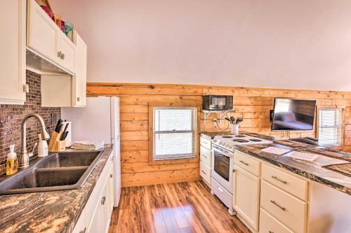 a kitchen with white appliances and wooden walls at Quaint Studio with Shared Beach Walk to Suttons Bay in Suttons Bay