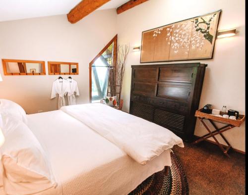a bedroom with a large white bed and a window at Sakura Ridge the Farm & Lodge in Hood River