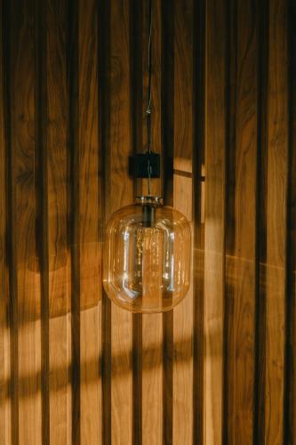 a glass light hanging from a wooden wall at Mtserlebi Resort in K'vishkhet'i