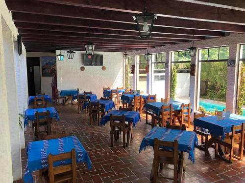 Habitación con mesas y sillas azules y piscina en Posada Montaña del Quetzal, en Cobán