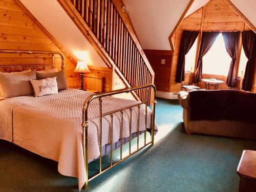 a bedroom with a bed in a room with a staircase at Susitna River Lodging, Suites in Talkeetna