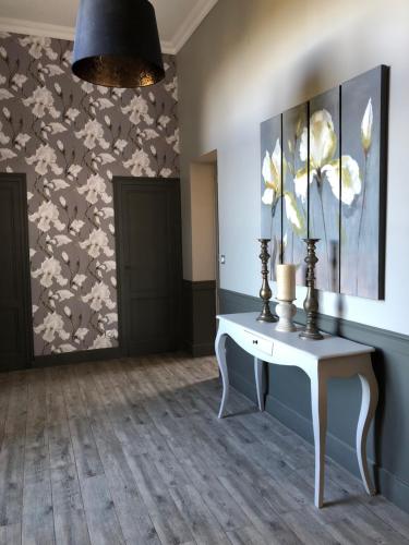 una habitación con una mesa y una pared con flores en Château Fauchey, en Cardan