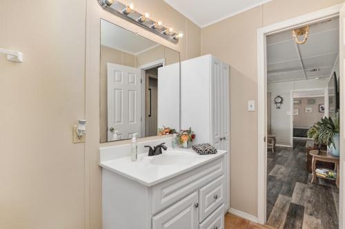 a white bathroom with a sink and a mirror at Family Forest Retreat, Paradise at Point Pleasant! 