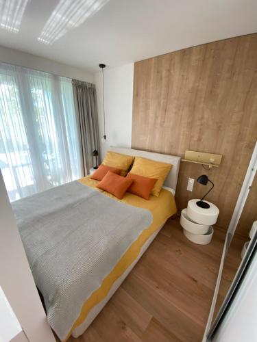 ein Schlafzimmer mit einem großen Bett mit orangefarbenen Kissen in der Unterkunft Premium Lelle Waterfront Resort Clyde in Balatonlelle