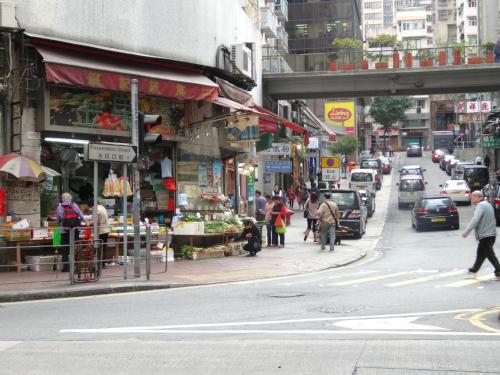 a busy city street with people walking on the sidewalk at Ibis Hong Kong Central & Sheung Wan in Hong Kong