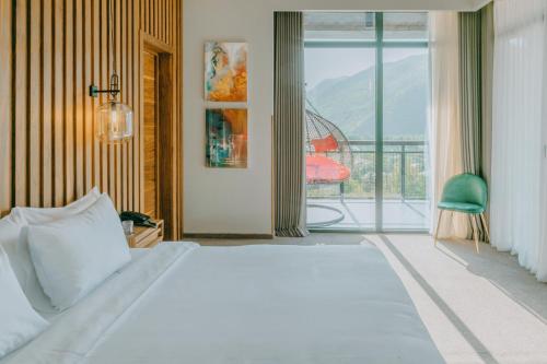 a bedroom with a large bed and a balcony at Mtserlebi Resort in K'vishkhet'i