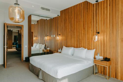 a bedroom with a large white bed and wooden walls at Mtserlebi Resort in K'vishkhet'i