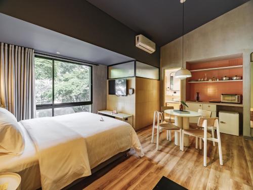 um quarto com uma cama, uma mesa e uma cozinha em The Somos Flats Provenza em Medellín