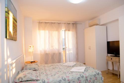- une petite chambre avec un lit et une télévision dans l'établissement City Central Studio , Ploiesti, à Ploieşti