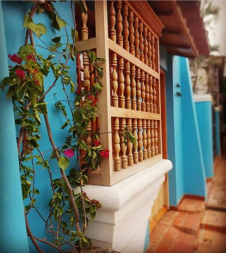 a window with flowers on the ledge of a blue building at Casa Isabelita in Mompos