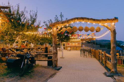 a pergola with lights and a motorcycle parked under it at Mtserlebi Resort in K'vishkhet'i