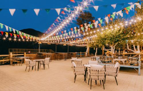 a patio with tables and chairs and lights at Mtserlebi Resort in K'vishkhet'i