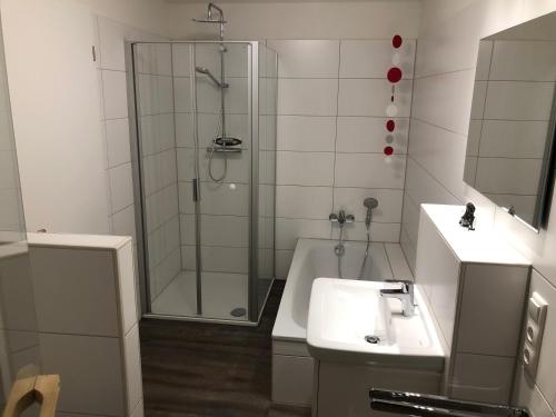 ein Badezimmer mit Dusche, Waschbecken und Badewanne in der Unterkunft Familienhaus an der Nordsee - Sauna - Kamin - Südterrasse direkt über dem Wasser in Wangerland