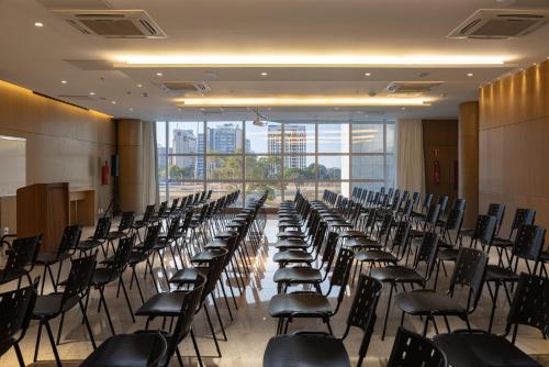 a row of chairs in a room with windows at Ramada by Wyndham Brasilia Alvorada in Brasilia
