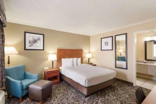 une chambre d'hôtel avec un lit et une chaise bleue dans l'établissement Best Western Conway, à Conway