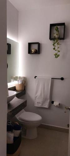 a white bathroom with a toilet and a sink at Estudio Marino in Nuevo Vallarta