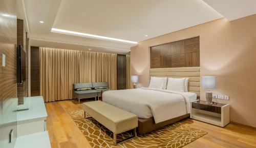 1 dormitorio con cama, escritorio y silla en Radisson Udaipur, en Udaipur