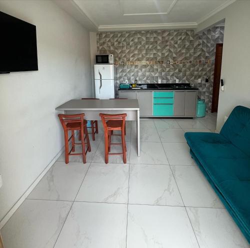 uma cozinha com uma mesa e cadeiras e um frigorífico em 330 METROS DO MAR, PRAIA DOS INGLESES, Piske Imóveis em Florianópolis