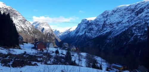 a snow covered mountain with a small village in the foreground at Stalheim Fjord og Fjellhytter in Stalheim
