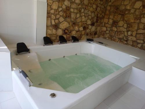 a white bath tub with two chairs in it at HOTEL BOUTIQUE 14 LANCEROS in Paipa