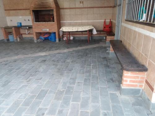 a room with a table and a bench on a brick floor at Casa Imponente Vila Atlântica - Beira Mar in Mongaguá