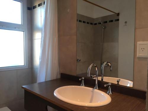 een badkamer met een wastafel en een bad bij COMPLEJO LAVANDAS in Balneario El Condor