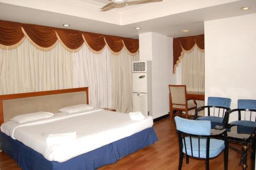 a bedroom with a bed and a table and chairs at Sitara Paradise in Hyderabad