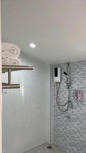 a shower in a bathroom with blue tiles at Cozy life ไออุ่น in Khao Kho