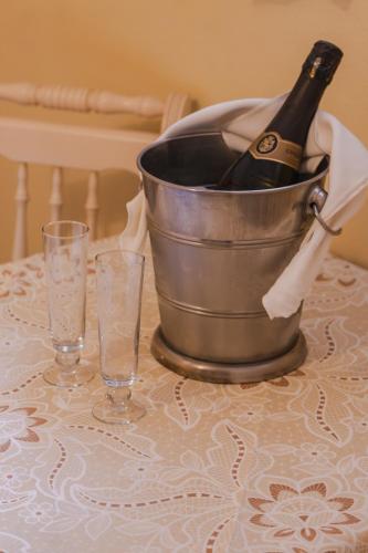 a bucket of champagne on a table with two glasses at Green Village Hotel in Monte Verde