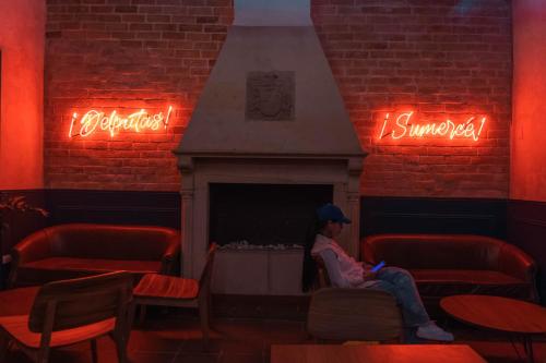a person sitting on a chair in a room with a fireplace at Masaya Bogotá in Bogotá