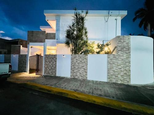 a house with white doors and a palm tree at Noè Hotel 1 king bedroom # 10 in Punta Cana