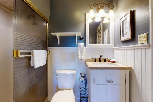 a bathroom with a toilet and a sink and a mirror at Our Anchor in St. George Island