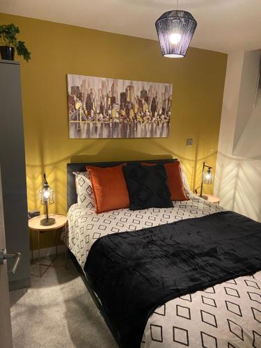 a bedroom with a black and white bed and a table at Home From Home Cosy 2 Bed Apartment in Bradford