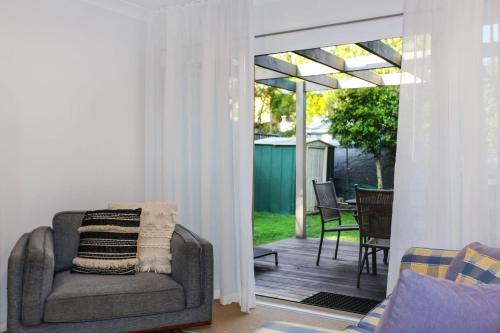 a living room with a chair and a patio at Vitamin Sea Pet Friendly in Hawks Nest