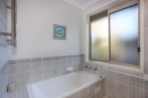 a bath tub in a bathroom with a window at Vitamin Sea Pet Friendly in Hawks Nest