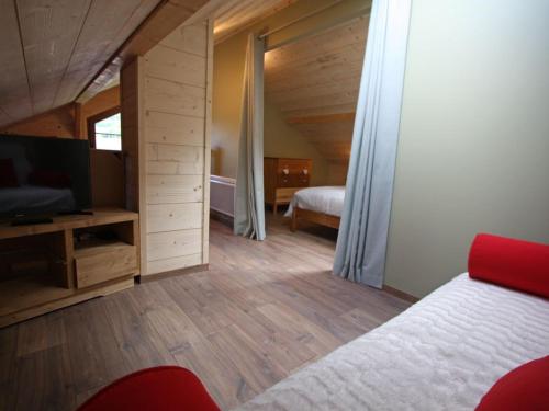 ein Schlafzimmer mit einem Bett und einem TV in einem Zimmer in der Unterkunft Gîte Lesseux, 3 pièces, 5 personnes - FR-1-589-300 in Lesseux
