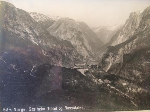 a painting of a mountain valley with a building on it at Stalheim Fjord og Fjellhytter in Stalheim