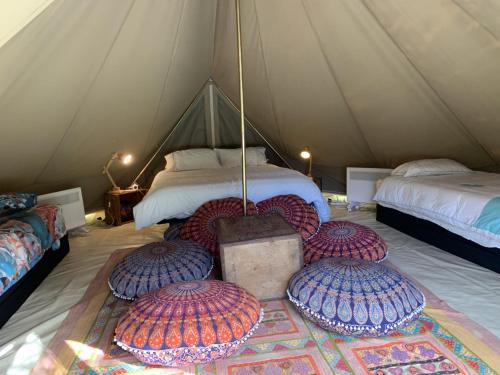 una habitación con 2 camas y 3 almohadas en una tienda de campaña en Luxury 6 metre Bell Tent & Outdoor Bathroom, WIFI, TV and firepit,, en Coodanup