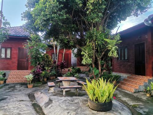 a garden with a table and a bench in front of a house at Kongkeo Guesthouse in Muang Phônsavan